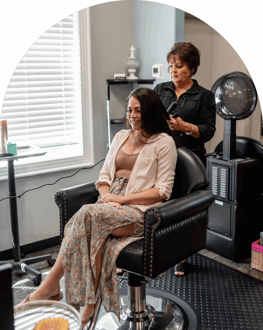 Woman getting hair styled in salon chair.