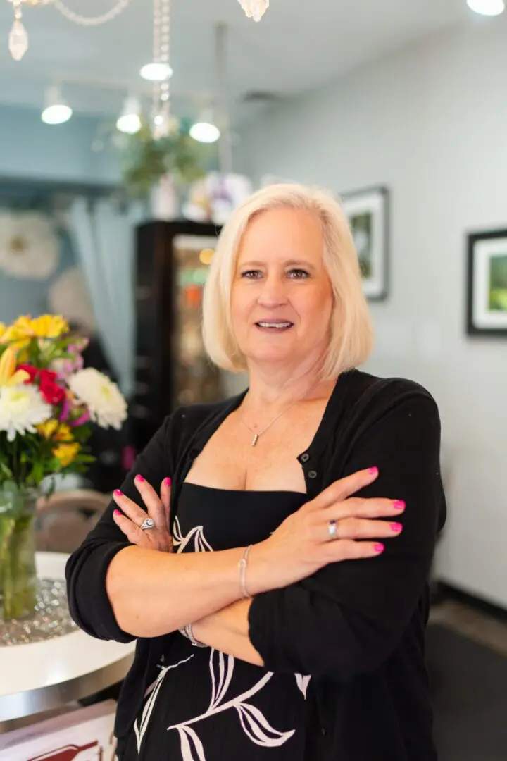 Woman standing in room with flowers.