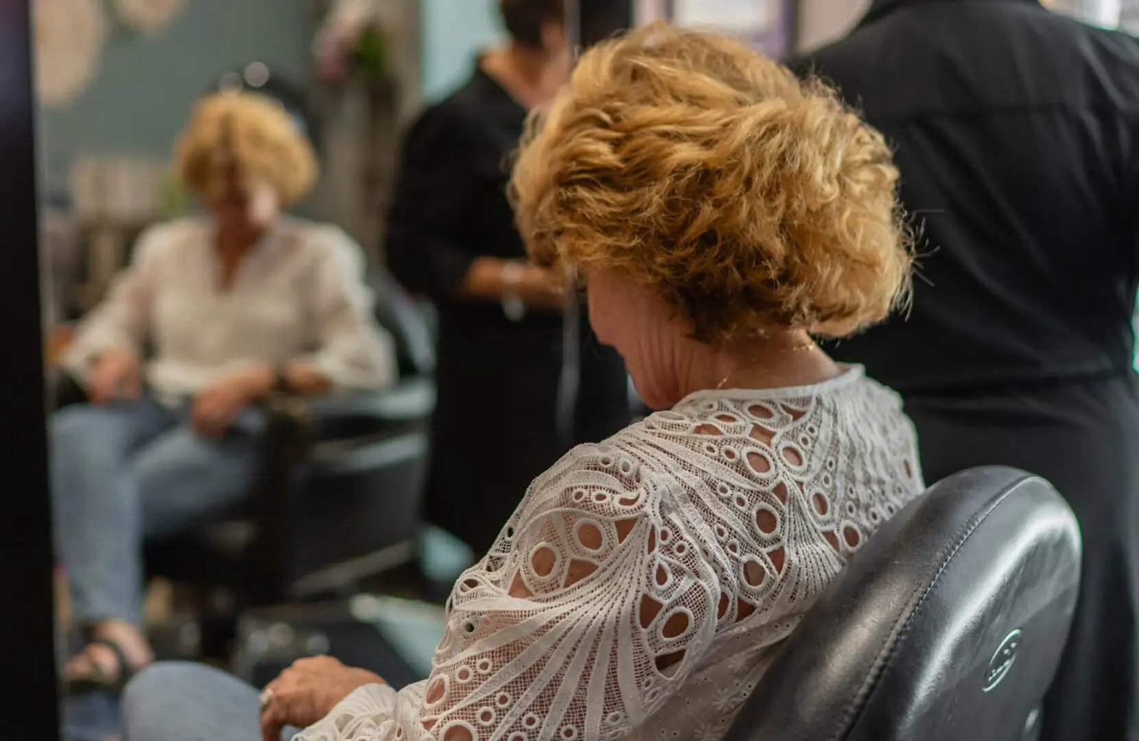 Woman sitting in a hair salon chair.